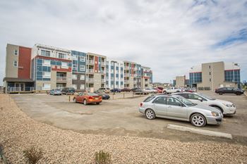 A parking lot with cars and apartment buildings in the background.